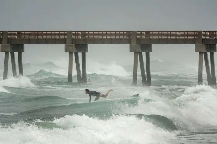 A surfer falls from his board next to Juno Beach Pier in Juno Beach, Florida, USA, 02 August 2020, as tropical storm Isaias passes near the Florida shores.